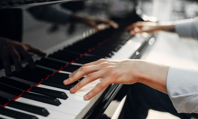 hands playing music on keyboard after buying a piano